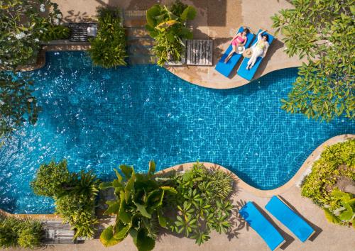 an overhead view of a swimming pool with people sitting on chairs by it at Railay Village Resort and Spa in Railay Beach