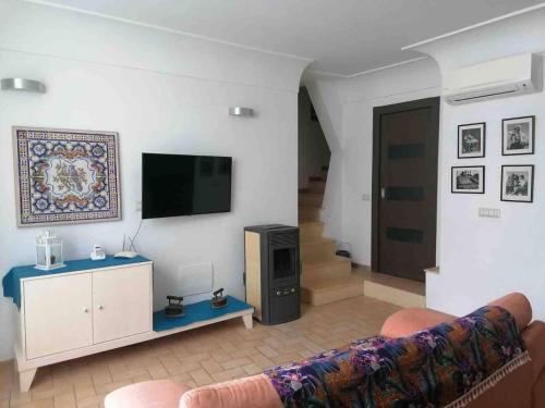 a living room with a couch and a flat screen tv at A casa dei Sasso vista mare mozzafiato in Positano