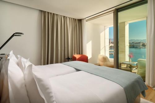 a hotel room with a bed and a large window at Hotel Ambasador in Split