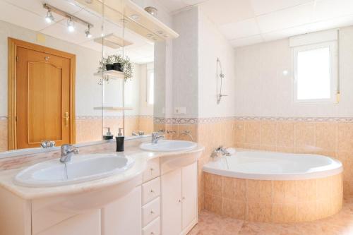 a bathroom with two sinks and a large mirror at Chalet Limonita in Mutxamel