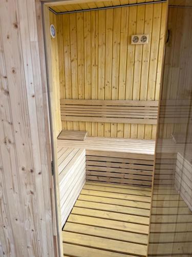 a wooden sauna with a wooden floor and wooden walls at Domek całoroczny HAWAJE nad jeziorem Kazub in Cieciorka