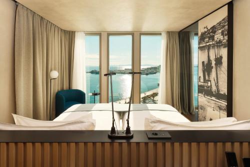 a hotel room with a bed and a large window at Hotel Ambasador in Split