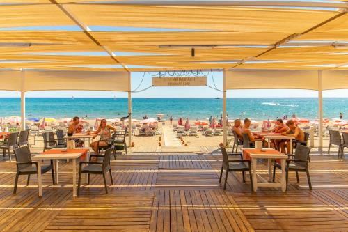 a beach with tables and chairs and people on the beach at Selenium Hotel in Side
