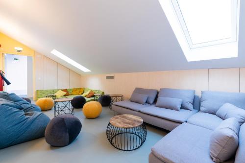 a living room with blue couches and a skylight at StudentVille Palmeiras in Lisbon