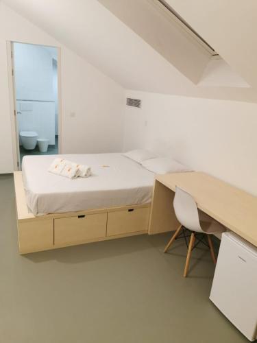 a bedroom with a bed and a desk and a mirror at StudentVille Palmeiras in Lisbon
