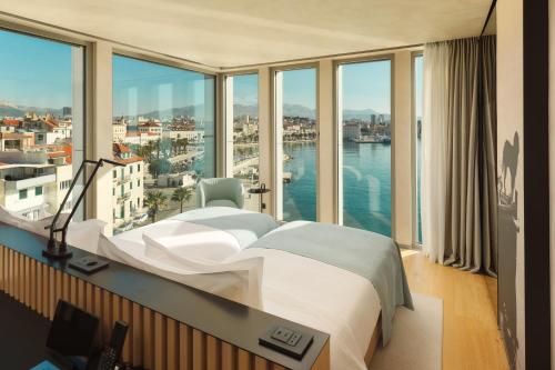 a bedroom with a bed and a view of the water at Hotel Ambasador in Split