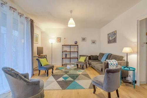 un salon avec un canapé, des chaises et une table dans l'établissement Le Fougères - 2 chambres, garage privé, à Rennes