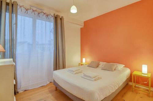 une chambre avec un lit blanc avec une grande fenêtre dans l'établissement Le Fougères - 2 chambres, garage privé, à Rennes