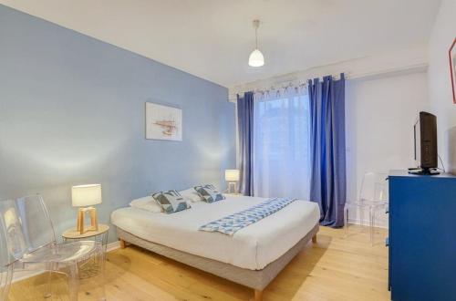 une chambre avec un grand lit aux murs bleus dans l'établissement Le Fougères - 2 chambres, garage privé, à Rennes