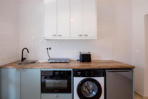 a kitchen with a washing machine and a sink at Albatross Apartments in Kassiopi