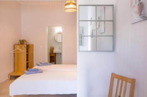 a bedroom with a white bed and a mirror at Albatross Apartments in Kassiopi