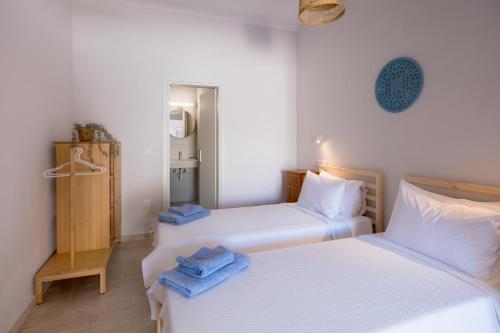 two twin beds in a room with white walls at Albatross Apartments in Kassiopi
