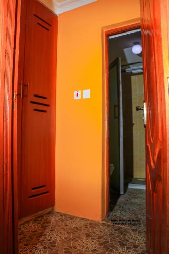 KiserianにあるHilly Home In Homeのオレンジ色の壁と扉のある廊下