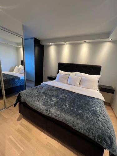 a bedroom with a large bed and a mirror at Spacious apartment with sea-view and sunset in Oslo