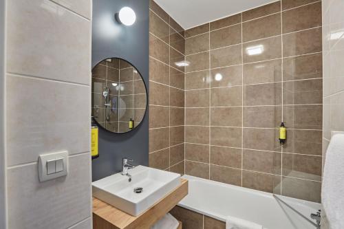 a bathroom with a sink and a mirror at Appart'hôtel Odalys City - Bioparc Lyon Est in Lyon