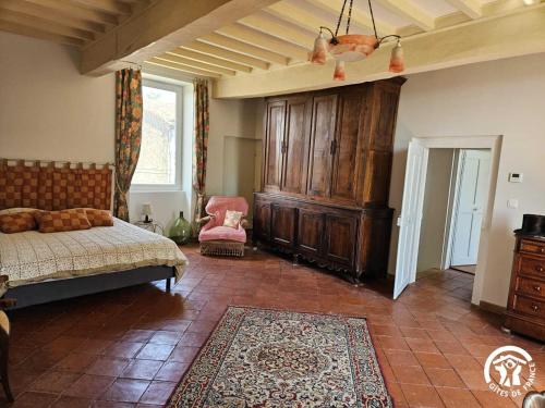 a bedroom with a bed and a large wooden cabinet at La surprise des jumelles in Castres