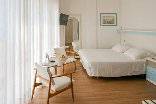 a bedroom with a bed and a table and chairs at Hotel Las Vegas in Lido di Jesolo