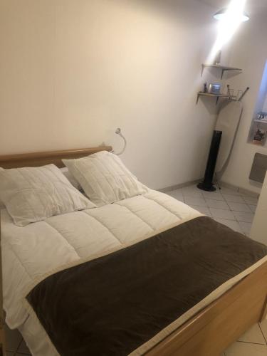 un lit dans une chambre avec une lumière sur le mur dans l'établissement Appartement T2 40 m2 Henri IV Centre-ville,1 chambre parking et balcon, à Aix-les-Bains