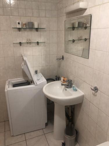une salle de bain blanche avec un lavabo et un miroir dans l'établissement Appartement T2 40 m2 Henri IV Centre-ville,1 chambre parking et balcon, à Aix-les-Bains