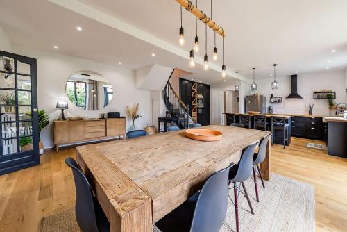 une cuisine et une salle à manger avec une table et des chaises en bois dans l'établissement CLOS HILY - Maison d'exception à Dinard - 10 pers, à Dinard