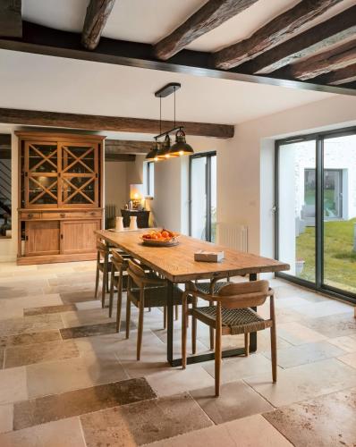 une grande salle à manger avec une table et des chaises en bois dans l'établissement Aux Petits Bourgeons, à Adainville