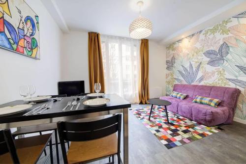 Il comprend une cuisine et un salon avec un canapé violet. dans l'établissement L'échappée - Bel appartement rénové et proche Gare, à Rennes