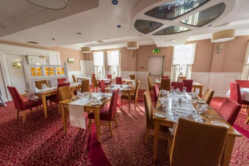 a dining room with wooden tables and red chairs at Downings Bay Hotel in Downings
