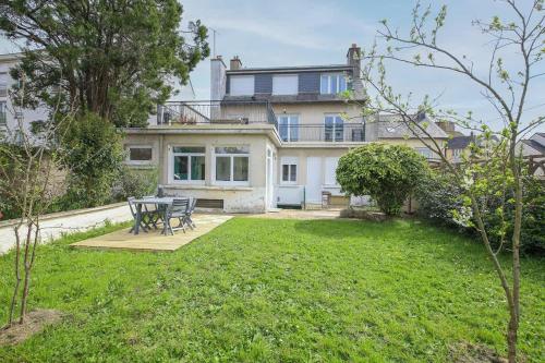 a house with a picnic table in a yard at Le Green, appartement rénové, 4 chambres et jardin in Saint-Jacques-de-la-Lande