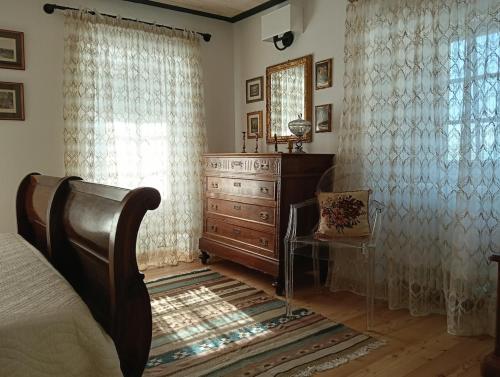 a bedroom with a dresser and a bed and a window at Casa Adamossi Lombardini in Alpe di Bondeno