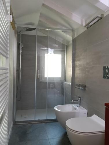 a bathroom with a shower and a toilet and a sink at Casa Adamossi Lombardini in Alpe di Bondeno