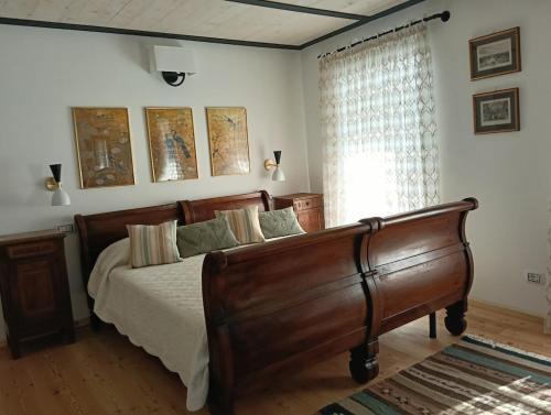 a bedroom with a wooden bed and a window at Casa Adamossi Lombardini in Alpe di Bondeno