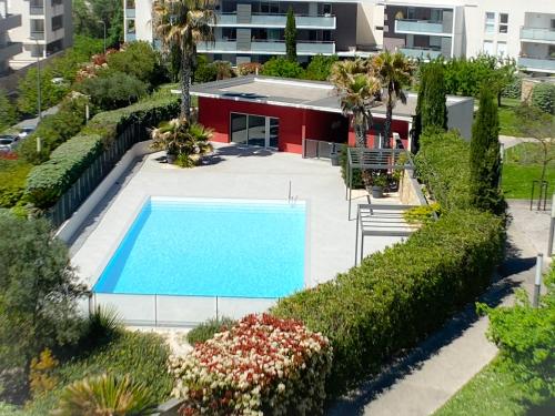 une vue aérienne d'une piscine dans un immeuble dans l'établissement Nouveau T3 Caudalie Piscine Proche Montpellier et Plages, à Montferrier-sur-Lez