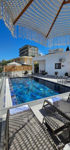 Vila Finnley في كساميل: حمام سباحة بمياه زرقاء أمام مبنى