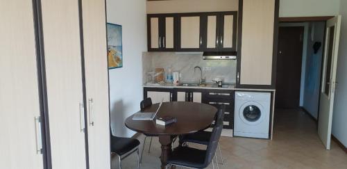 a kitchen with a table and a sink and a washing machine at Oasis Resort&Spa Lozenets Studio in Lozenets