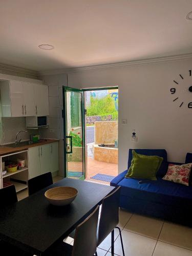 a living room with a blue couch and a clock on the wall at ApKanariooo in Frontera