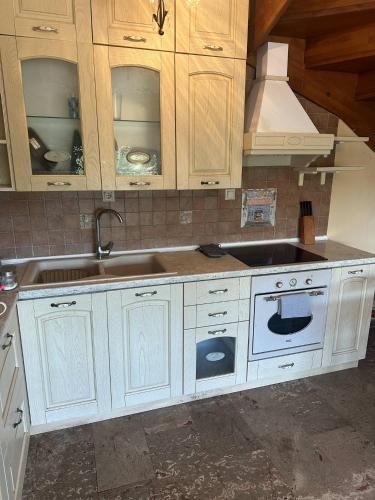 a kitchen with white cabinets and a sink at Villa canty in Nea Potidaea