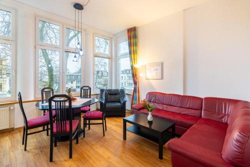a living room with a red couch and a table at Haus Zander in Heringsdorf