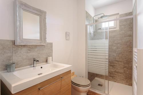 a bathroom with a sink and a toilet and a shower at Gabae - Les Volets Gris in Puyravault
