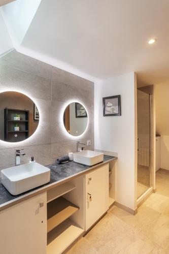 une salle de bain avec deux lavabos et un miroir dans l'établissement Emeraude Duplex 2 personnes à Dinan, à Dinan