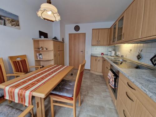 a kitchen with a wooden table and a counter top at Ferienwohnung "Fehn-Moor" 95156 in Rhauderfehn