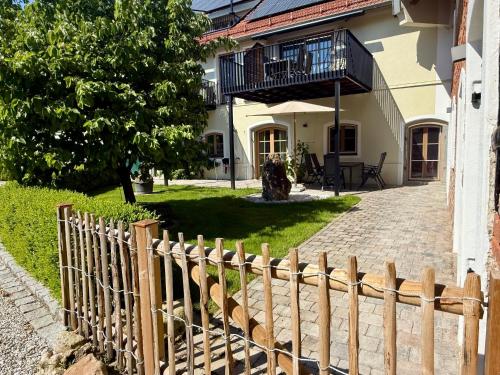 a wooden fence in front of a house at Gut Schwarz-n Hof Ferienwohnungen in Bad Griesbach
