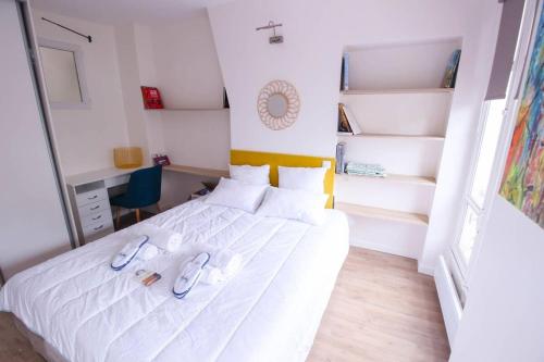 - une chambre dotée d'un lit blanc avec des chaussures dans l'établissement Cosy, Tour Eiffel - Champs de Mars, à Paris