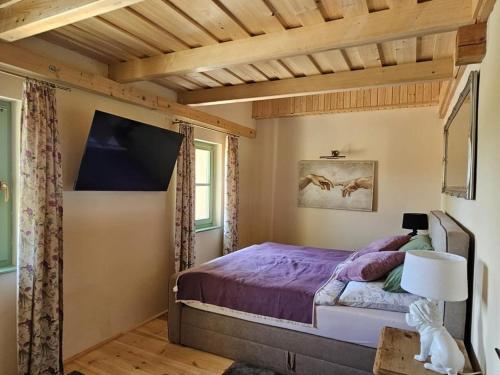 a bedroom with a bed with a purple comforter at Darya Pince in Tormafölde
