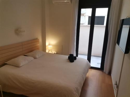 Málaga Centro, 2 habs, Piscina en azotea, 2 terrazas y parking privado في مالقة: غرفة نوم بسرير أبيض ونافذة كبيرة