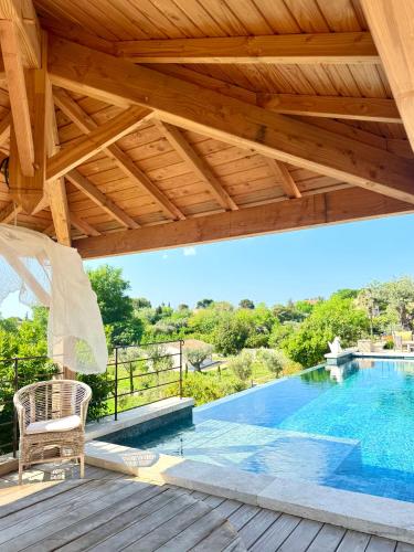 a wooden deck with a swimming pool and an umbrella at LA BASTIDE DES CULS-ROUSSET in Marseille
