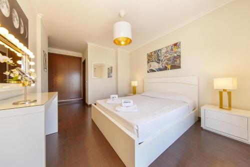 a bedroom with a white bed and a clock on the wall at B03 - Luxury 2 Bed Lagos Marina in Lagos