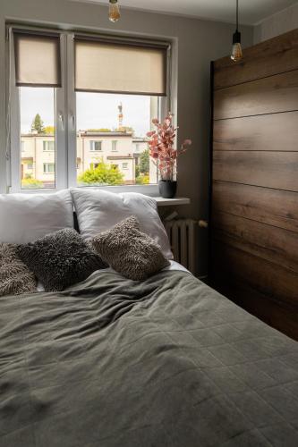 a bed with two pillows and a window in a bedroom at Hexagon Studio Comfort in Gdańsk