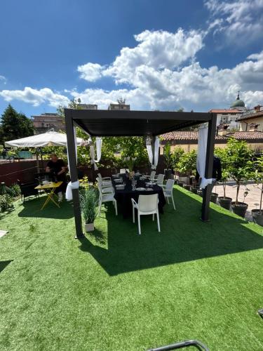 a gazebo with a table and chairs on grass at casa carmelo in Schio
