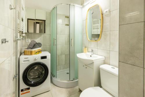 a bathroom with a washing machine and a sink at Hexagon Studio Comfort in Gdańsk