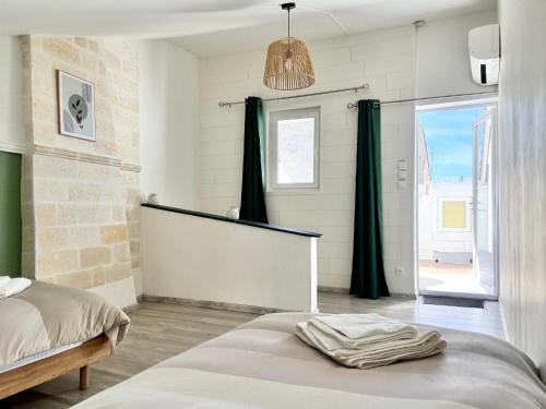 a bedroom with a bed and a large window at Gîte Molière in Sallèles-dʼAude
